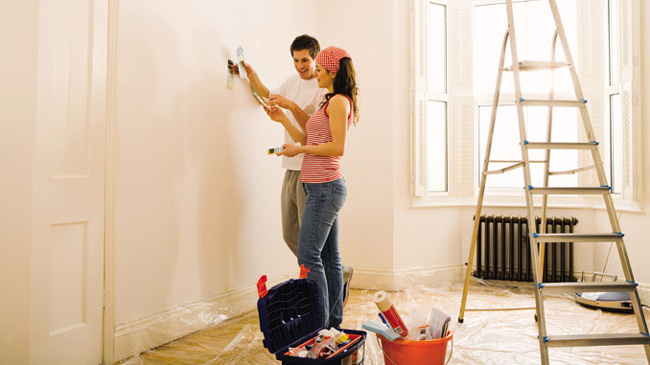 casal preparando parede para revestimento