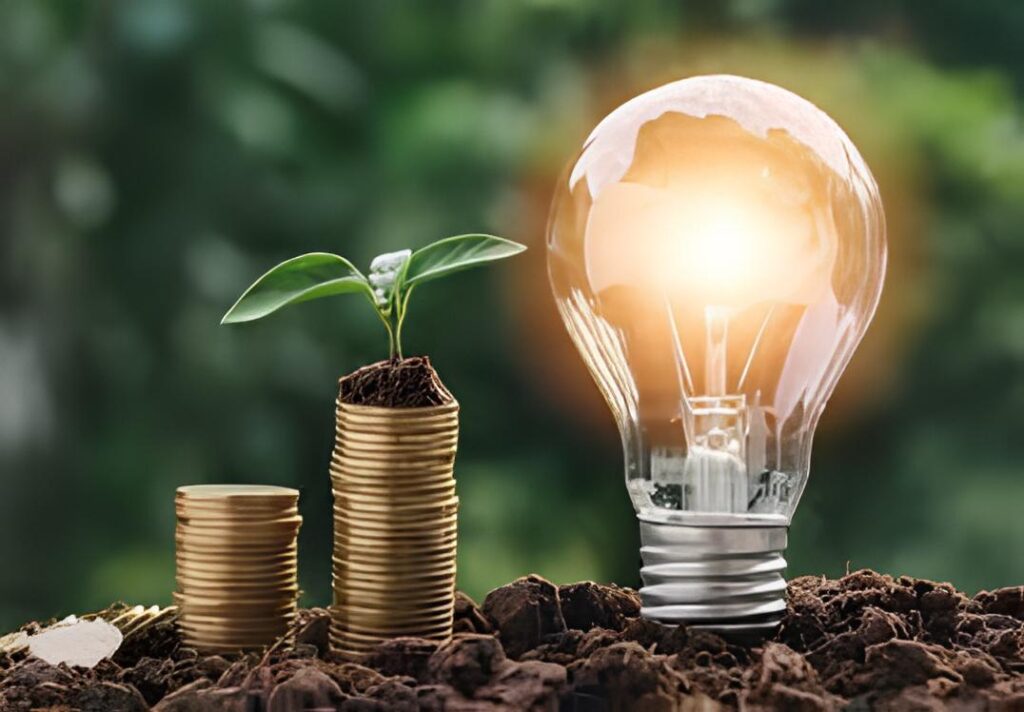 Representação de uma lâmpada com o bocal na terra e uma pilha de moedas ao lado, simbolizando sustentabilidade e economia de energia em casa.